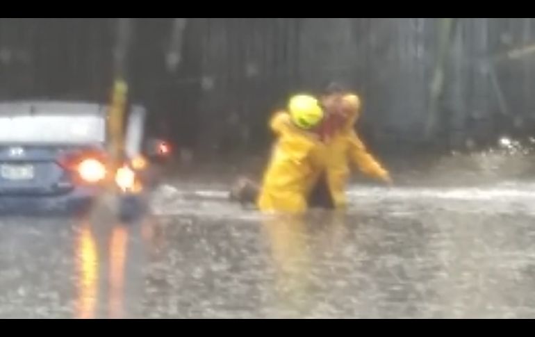 En el cruce de avenida Patria y Ávila Camacho los oficiales bomberos rescataron a dos personas que no podían salir de su vehículo. ESPECIAL/Bomberos de Zapopan