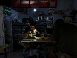 Muchos se han visto forzados a depender de generadores para sus hogares y comer a la luz de sus celulares. AP/O. Zhang