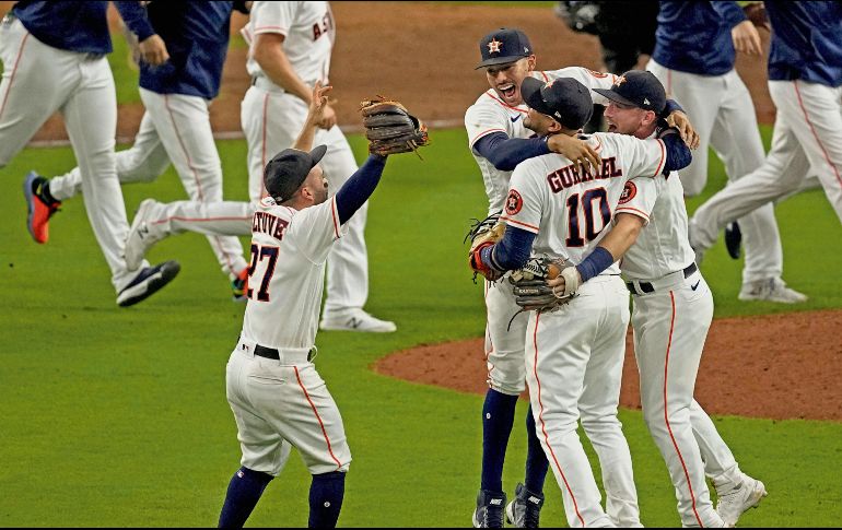 José Altuve corre a abrazar a sus compañeros al caer el último out con el que ganaron el sexto juego a Boston. AP/S. Ogrocki