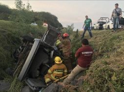 Elementos de Protección Civil Jalisco extrajeron los cuerpos que quedaron prensados en el vehículo que terminó en una cuneta a un costado de la vía. ESPECIAL