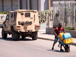 Un hombre carga con bidones en busa de gasolina. La carestía de los combustibles ha provocado jornadas de protestas. EFE/O. Barría