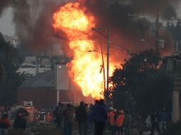 Personal de Pemex continúa la quema controlada de la toma clandestina para poder sellar el ducto que explotó, lo cual afectó 54 casas. AP / P. Spencer