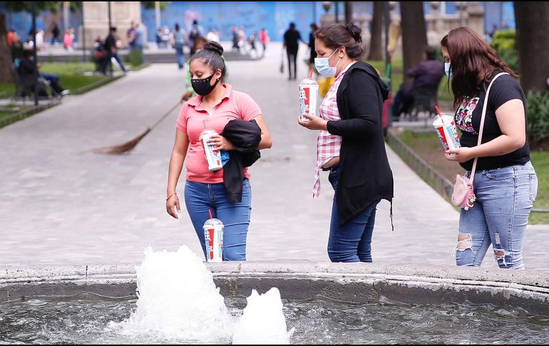 Personas con cubrebocas caminan por un parque del Centro Histórico de la Ciudad de México. EFE/C. Ramírez
