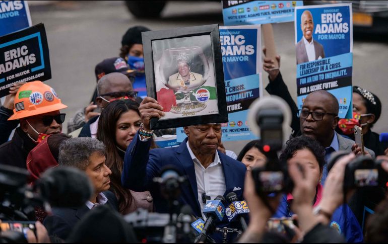 El nuevo alcalde de Nueva York, Eric Adams (C), sostiene un retrato de su difunta madre Dorothy Mae Adams mientras habla con medios de comunicación. AFP/E. Jones