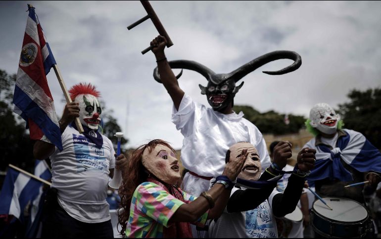 Personas con máscaras que hacen referencia al presidente de Nicaragua, Daniel Ortega (d), y su esposa la vicepresidenta Rosario Murillo (i), posan durante una protesta de nicaragüenses contra las elecciones presidenciales en su país, en San José, Costa Rica. EFE/J. Arguedas