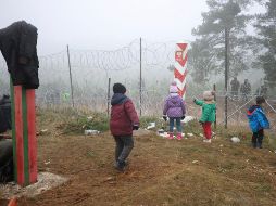 Migrantes se ven cerca de una malla en Polonia, cerca de la frontera con Grodno, Bielorrusia. AP/BelTA/L. Shcheglov