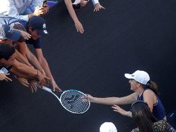 La polaca Iga Swiatek regala su raqueta a unos fans tras  ganar el juego ante la española Paula Badosa, en el torneo AKRON WTA Finals. EFE/ F. Guasco