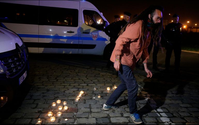 Activista por los migrantes deja veladoras en el puerto de Calais. La de ayer es la mayor tragedia en le canal de la Mancha. AP/M. Spingler