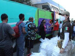 Migrantes hacen fila hoy para subir a un autobús tras un acuerdo con el Instituto Nacional de Migración, en el municipio de Escuintla, Chiapas. EFE/J. Blanco