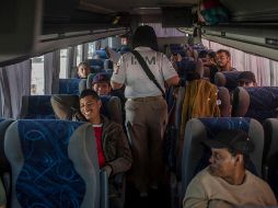 Desde hace una semana en torno a 3 mil personas, la mayoría haitianos, acampan bajo los árboles y en el estacionamiento del estadio de futbol de Tapachula a la espera de poder subirse a uno de los autobuses que van llegando. AP / F. Marquez