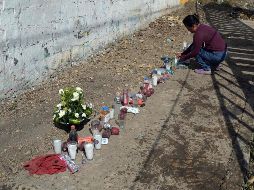 Una mujer enciende una veladora en el sitio del accidente en la carretera Tuxtla-Chiapa de Corzo donde 55 inmigrantes perdieron la vida tras un accidente. AFP / A. Estrella