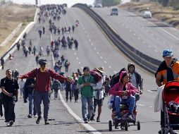 Migrantes caminan este viernes por la autopista México-Puebla, en el estado de Puebla. El atropello se registró en esta vía. Xinhua/C. Pacheco)