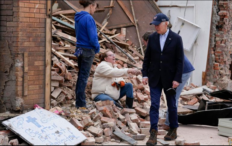 Con una gorra de béisbol y un traje sin corbata, el presidente estrechó la mano de una mujer sentada entre los escombros de un edificio derrumbado. AP/A. Harnik