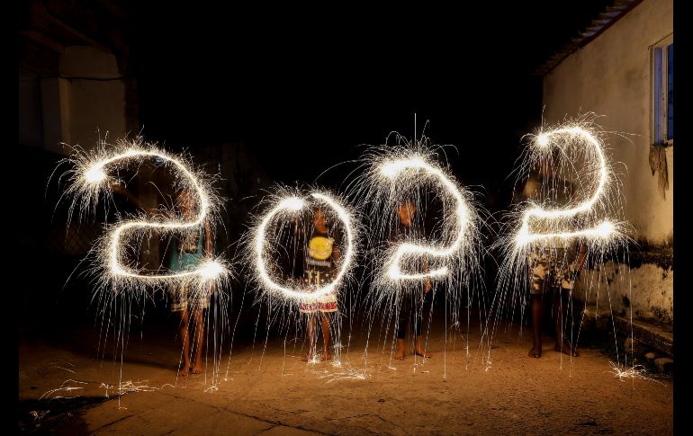 Niños dibujan con luces el año 2022 durante festejos en Colombo, Sri Lanka. EFE/C. Karunarathne