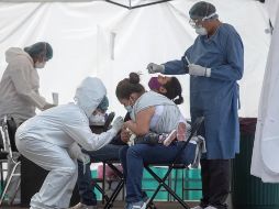 Una señora ayuda a su hija durante una prueba para detectar el COVID en el hospital del IMSS 