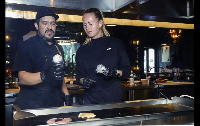 Javier Valenzuela y Marie Bouzková en la plancha con la carne. GENTE BIEN JALISCO/ CLAUDIO JIMENO
