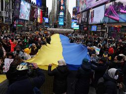 Reunidos en torno a una gigantesca bandera de Ucrania que sostenían unas cuarenta personas mientras la hacían ondear, los manifestantes cantaron su himno y reclamaron apoyo más decidido para su país. EFE / J. Lane
