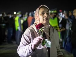 Madre de estudiante afectado sostiene una rosa mientras espera su arribo. AP/M. Elshamy