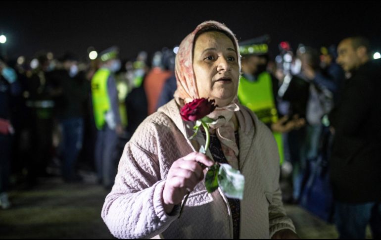 Madre de estudiante afectado sostiene una rosa mientras espera su arribo. AP/M. Elshamy