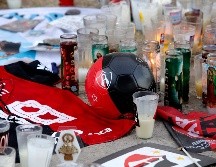 Detalla general de veladoras y ofrendas dedicadas a los atlistas lesionados durante la bronca en La Corregidora. AFP/U. Ruiz