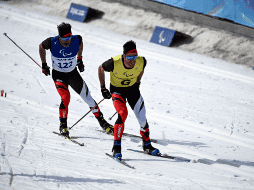 Algunos deportistas como el multicampeón Brian McKeever (izquierda, junto a su guía) decidieron participar en playera cuando la temperatura alcanzó los 17 grados Celsius. AFP / I. Suwanrumpha