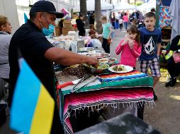 Voluntario mexicano prepara tacos en un campo de refugiados improvisado en Tijuana. AP/G. Bull