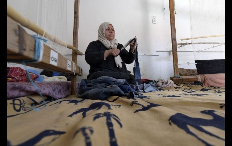 Viejos gorros de lana o calcetines sirven como materias primas para un bello tapiz negro, beige y con tonos dorados. AFP/F. Belaid
