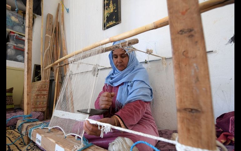 Viejos gorros de lana o calcetines sirven como materias primas para un bello tapiz negro, beige y con tonos dorados. AFP/F. Belaid