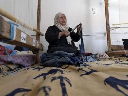 Viejos gorros de lana o calcetines sirven como materias primas para un bello tapiz negro, beige y con tonos dorados. AFP/F. Belaid