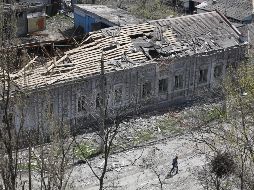 Una persona camina cerca de un edificio dañado en Mariúpol. XINHUA