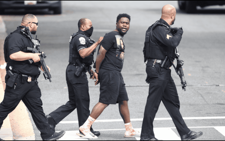 Varios agentes escoltaron a un joven esposado, aunque aún no se sabe si era el culpable de los disparos. ESPECIAL