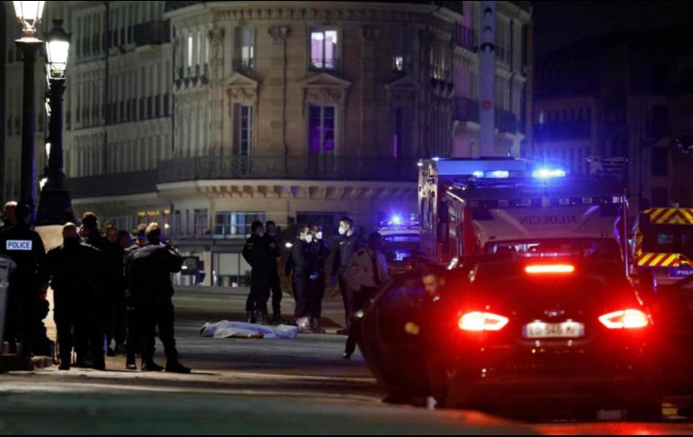 Oficiales investigan el cuerpo de uno de los ocupantes que iba arriba del automóvil que trató de embestir a la la policía. AFP/L. Marin