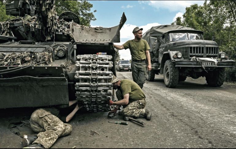 Los miembros de las tropas ucranianas reparan un tanque de batalla principal en la región oriental de Ucrania de Donbás. AFP