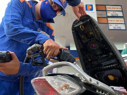 Un asistente bombea gasolina a una moto en Hanói. En todo el mundo, los conductores están repensando sus hábitos y finanzas personales en medio de los precios vertiginosos de la gasolina y el diésel. AP/H. Dinh