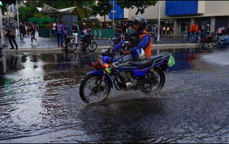 Un motociclista atraviesa una calle inundada en Venezuela, que también registra lluvias por el fenómeno. AP/A. Cubillos