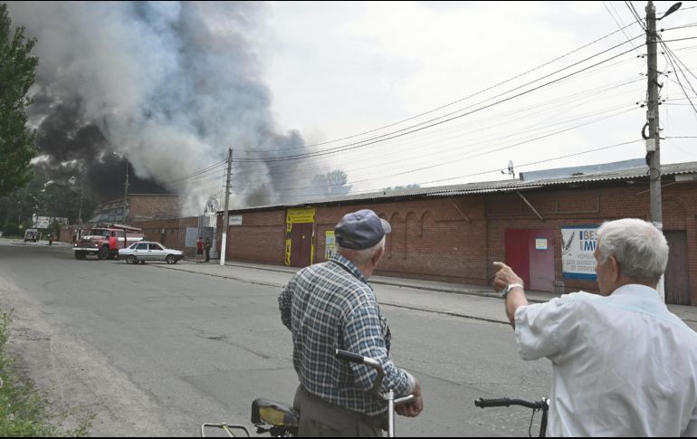 Los transeúntes observan cómo se eleva el humo del mercado central de Sloviansk, al norte de Kramatosk luego de ser atacado pos misiles rusos lanzados desde el mar Negro. AFP