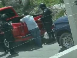 De acuerdo a las imágenes captadas, el conductor de una camioneta color rojo se encuentra retenido y tres elementos de la Policía Estatal Preventiva están muy cerca de él. ESPECIAL