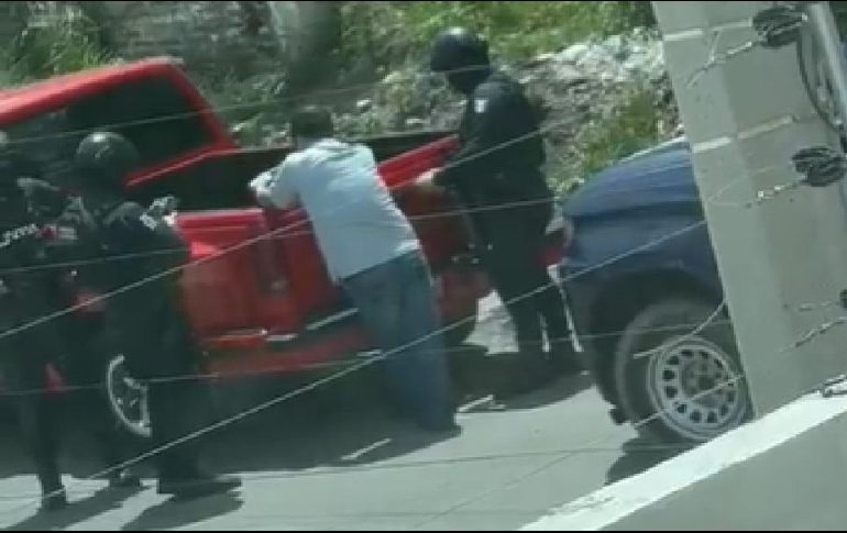 De acuerdo a las imágenes captadas, el conductor de una camioneta color rojo se encuentra retenido y tres elementos de la Policía Estatal Preventiva están muy cerca de él. ESPECIAL