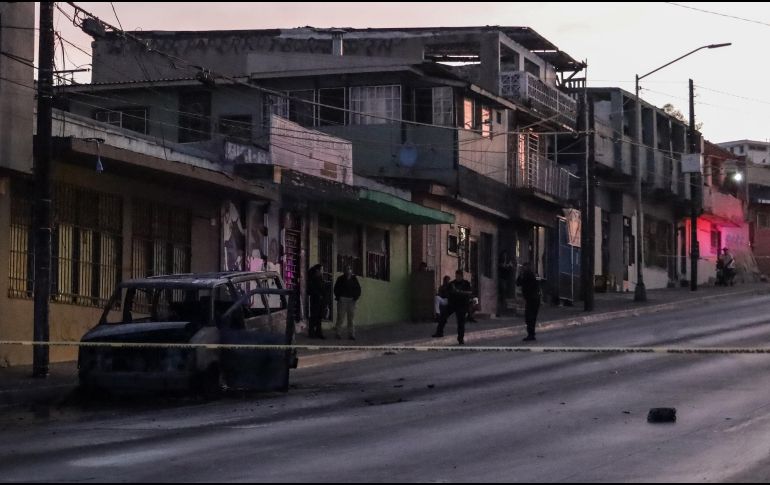 Miembros de la Policía Estatal resguardan una unidad de transporte publico incendiada el 12 de agosto de 2022 en Tijuana. EFE/J. Terríquez