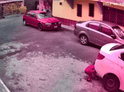 La pareja intenta mover el auto hasta que el conductor avanza para liberar al niño. TWITTER