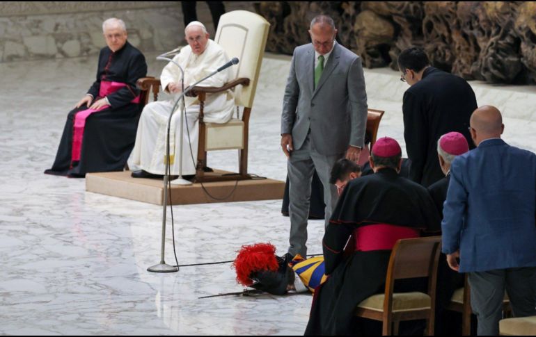 El papa Francisco observa preocupado al guardia, mientras personas a su alrededor intentan reanimarlo. EWTN