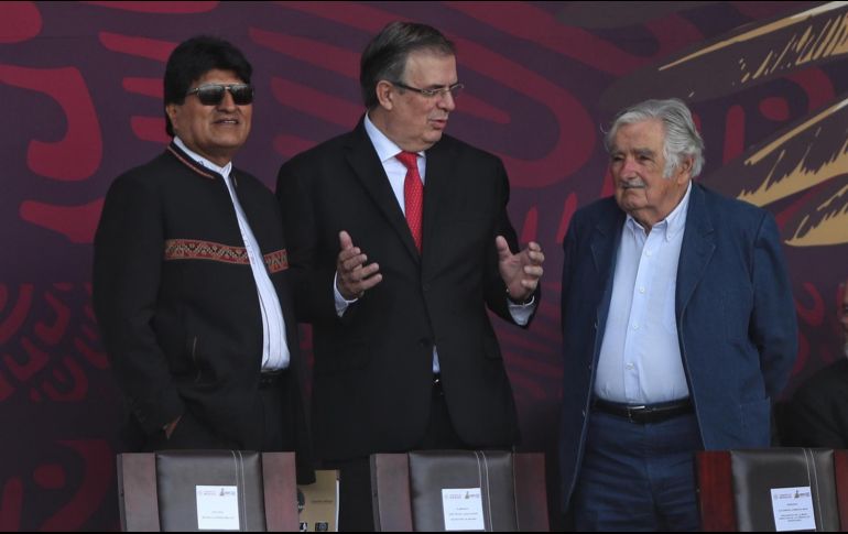 El secretario de Relaciones Exteriores de México, Marcelo Ebrard (c), conversa con el expresidente de Bolivia, Evo Morales (i) y José Mujica (d), expresidente de Uruguay, durante el desfile militar en conmemoración de los 212 años de Independencia de México. . EFE / S. Gutiérrez