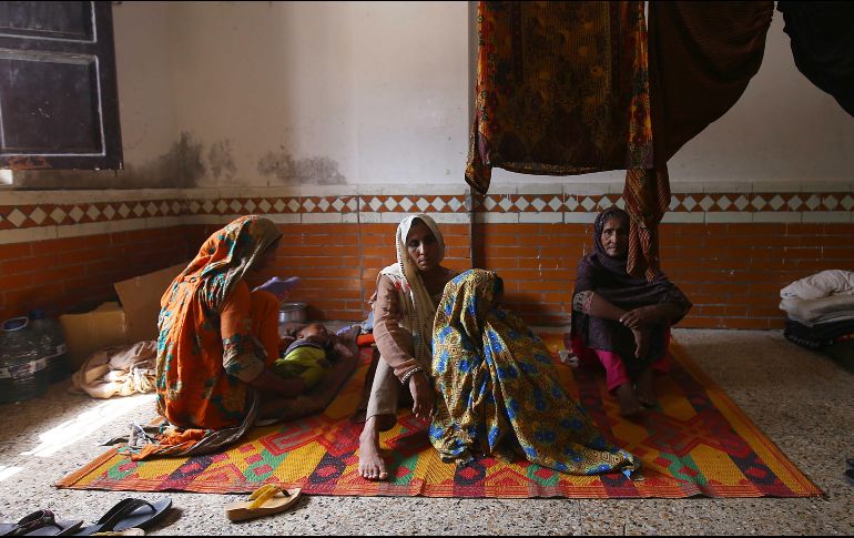 Varias personas descansan en una escuela acondicionada como refugio en la provincia de Sindh. EFE/S. Akber