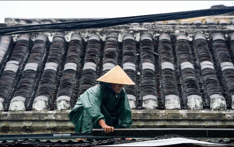 Un habitante refuerza el techo de su casa ante la inminente llegada de 
