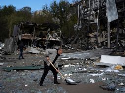 Un hombre limpia los escombros de una tienda de autopartes luego del ataque ruso en Ucrania. AP / L. Correa