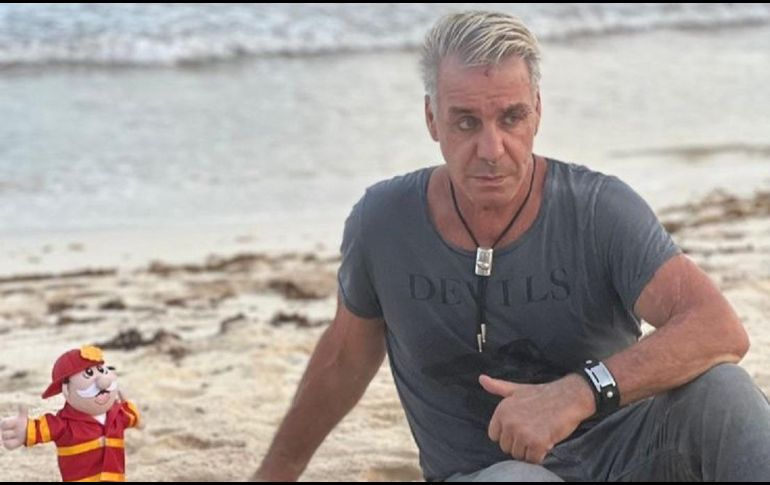 En la foto se puede apreciar que está sentado sobre la arena sosteniendo a un Dr. Simi vestido de bombero y al fondo se puede ver una hermosa vista de la playa. ESPECIAL