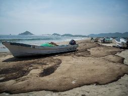 Embarcaciones permanecen varadas en la playa debido a que la pesca está limitada por el daño ambiental. EFE/L. Villalobos