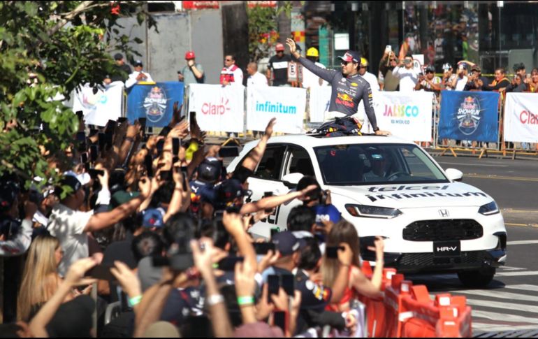 Niños, jóvenes y adultos mayores vestidos de pies a cabeza con el azul marino que caracteriza a la escudería del piloto tapatío intentan resguardarse de los rayos del sol, mientras el ánimo no desiste. EL INFORMADOR / A. Camacho