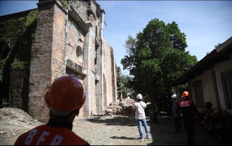 Bomberos inspeccionan los daños en una iglesia en el pueblo de Dingras. EFE/B. Sipin