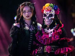 Personas disfrazadas caminan por las calle durante una celebración antes en Guangzhou, China. AFP